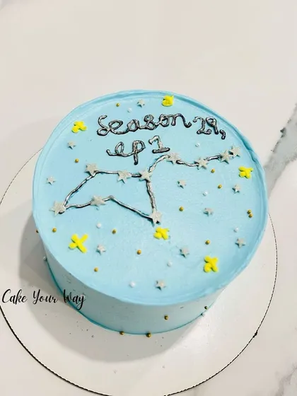 A celestial-themed bento cake for an astrology lover. This mini cake features a hand-piped constellation against a starry blue background, marking the start of "Season 28, ep 1."