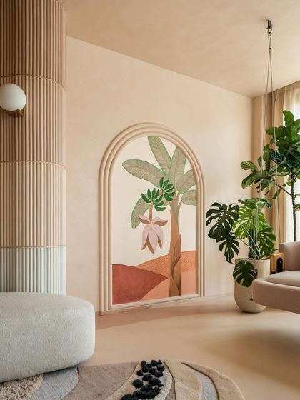 This arched mural, featuring a hand-painted banana tree, adds a touch of personalized art and nature to the living space. It's one of the many details that makes this home a true sanctuary.