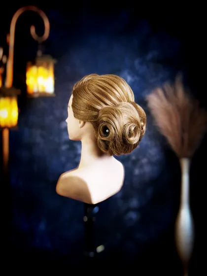A three-quarter view of the swirled chignon, showing the beautiful shape and volume. Students learn to create balanced and flattering updos from all angles.