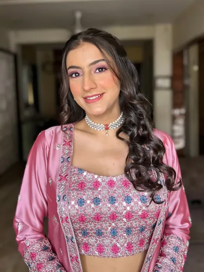 A lovely pink-themed look for a daytime event. The makeup features rosy cheeks and shimmery pink eyeshadow, complemented by a pearl choker.