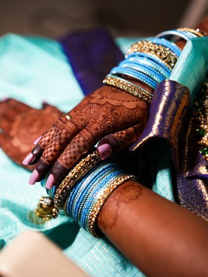The henna stain looks beautiful with the bride's blue and gold bangles.