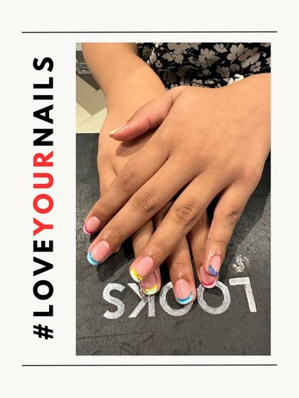 A fun and colorful take on the French manicure. Each nail features a different pastel-colored tip, creating a playful and trendy rainbow effect that's perfect for summer.