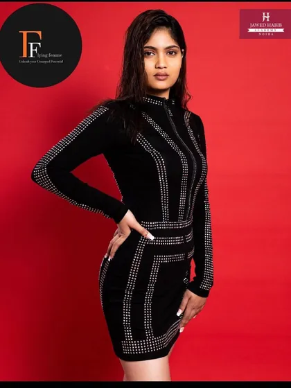A model in a black studded dress, with makeup and hair done by our students, showcasing a chic and modern look.