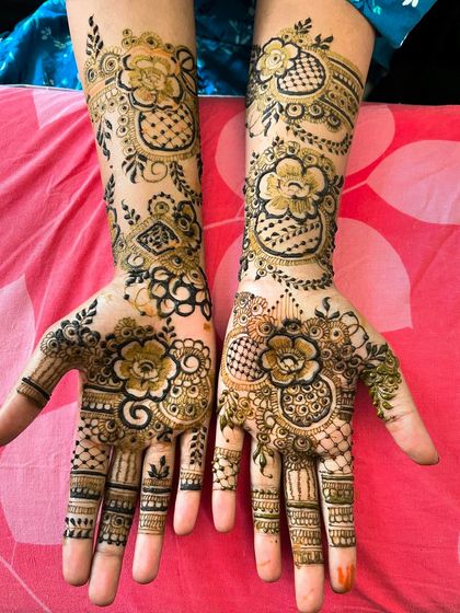 A lovely floral and checkerboard design that covers the hands and wrists. The combination of bold flowers and delicate net patterns creates a balanced and traditional look.