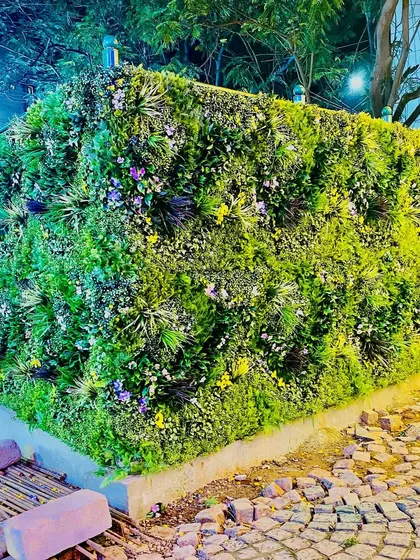 We covered this entire outdoor structure in a mix of colorful artificial foliage. This project, located in a public space, shows the durability and scale of our installations for high-traffic exterior environments.