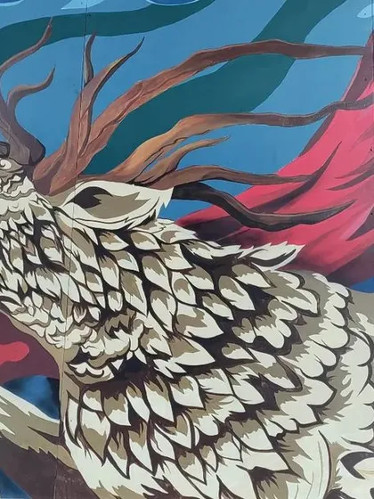 Detail shot of the mythical deer from the Cuppa mural. The design incorporates intricate, feather like patterns and flowing red fabric to create a sense of motion and majesty.