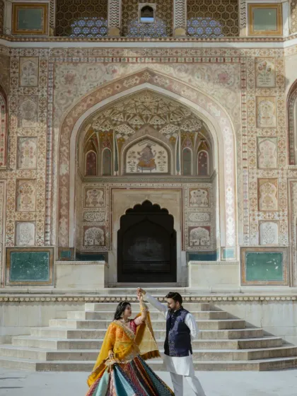 Dancing in front of the magnificent Ganesh Pol at Amber Fort. This shot captures both the grandeur of the location and the couple's happy, carefree spirit, making it a perfect pre-wedding memory.