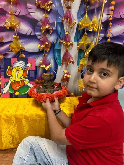 A young boy proudly displays his clay Ganesha, made with his own hands during our workshop.