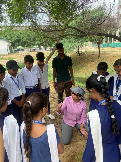 A member of Quota International teaches a group of school children about the importance of planting trees during their joint activity.