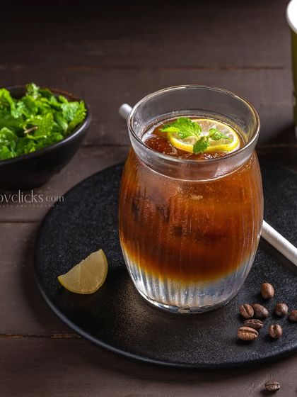 A coffee-based mocktail with lemon and mint, offering a refreshing twist on iced coffee.