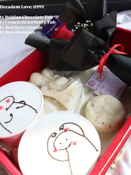 The "Decadent Love" hamper in a red box, featuring two dessert tubs, candles, and a rose bouquet for a classic romantic gesture.