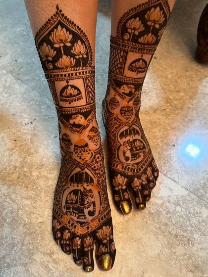 This intricate foot design features elephants, lotuses, and traditional kalash motifs, designed to match the bride's hand mehndi.