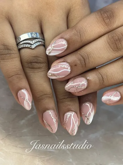 A similar swirl design on a pink base with a touch of silver glitter. The lines are delicate and create beautiful movement across the nails.