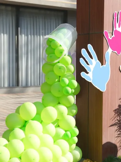 Creative decor elements like this spilling bucket of green balloons add a playful and artistic touch to the party entrance.