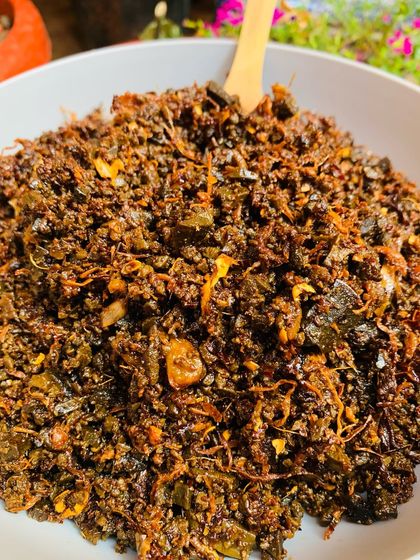 This is a special pickle made with smoked meat and Aneshi, or fermented taro leaves. It has a very deep, smoky, and slightly sour taste that is very traditional.