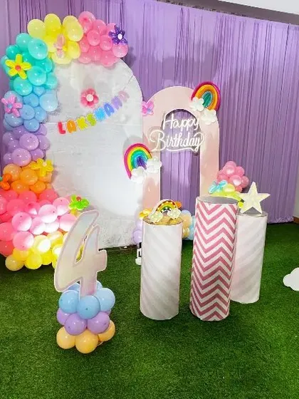 A wider view of the Rainbow theme setup, showing the arrangement of the backdrops, props, and the custom balloon number '4'.