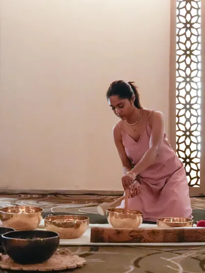 Preparing the sound bowls for a session at a corporate retreat. The serene setting of a hotel or resort enhances the restorative effects of the sound bath for employees.
