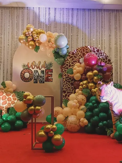 A chic and modern take on the "Wild One" theme, using animal-print backdrops and a stylish arrangement of green, gold, and neutral-colored balloons.