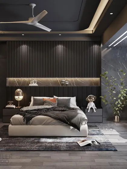 Another take on dark mode. This bedroom uses vertical fluted paneling and a marble headboard shelf to create a sophisticated and moody atmosphere. Whimsical dog figurines add a touch of personality.