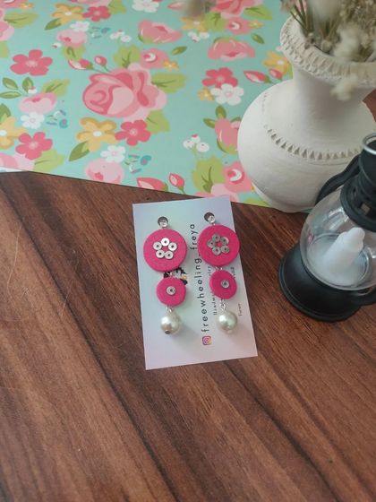 These tiered fabric earrings with pearl drops are a modern and chic design. They are available in pink, black, and teal, and are incredibly lightweight and comfortable.