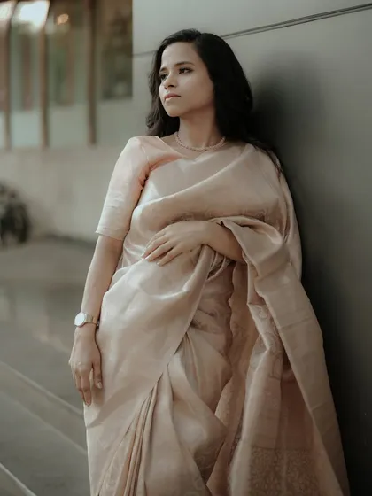 A pensive and elegant portrait, capturing the beautiful drape and sheen of the traditional saree.