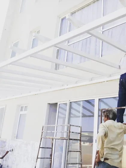 A behind-the-scenes shot of my team painting the white pergola. We take great care in every step of the process to ensure a high-quality finish.