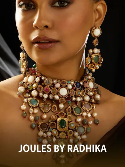 A close-up of the magnificent navratan-style necklace worn by Aneri Vajani, featuring an array of colorful gemstones and pearls.