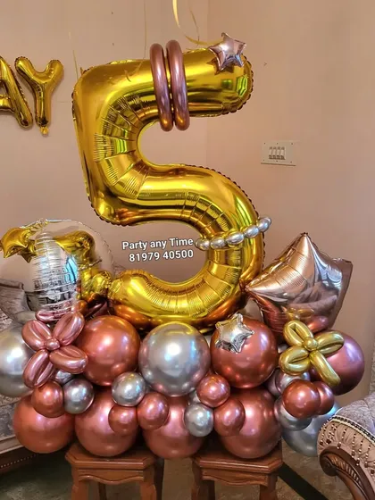 A 5th birthday number bouquet in gold, silver, and rose gold.