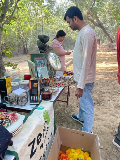 A visitor browses the collection of pre-loved home decor, jewelry, and mugs at our outdoor thrift stall. There's always something unique and useful to discover.