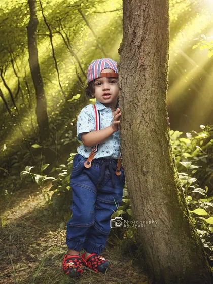 A playful moment in the woods, with sunbeams streaming through the trees. This image captures the sense of adventure and wonder that defines childhood.