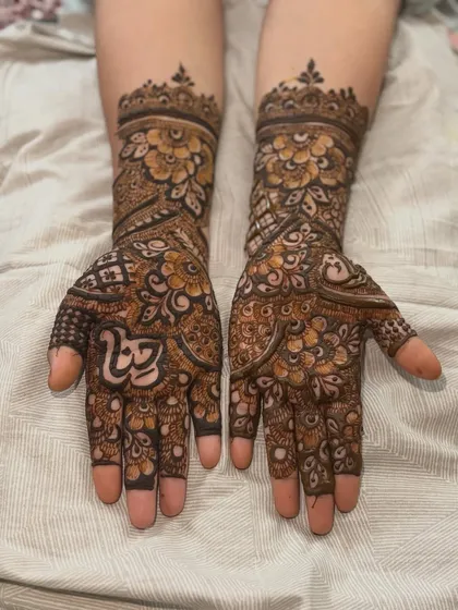 A complete view of a heavy bridal design, extending up the forearms. The symmetry and density of the pattern are key to this traditional bridal style.