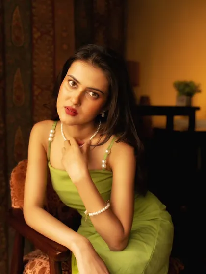 A beautiful, classic portrait pose. The soft focus on the background helps the subject stand out, even in a detailed room.