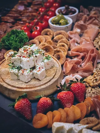 A feast for the eyes and the palate. This lavish grazing table features a curated selection of artisanal cheeses, cured meats, fresh fruits, and nuts. It's perfect for creating a relaxed, social atmosphere where guests can mingle and enjoy.