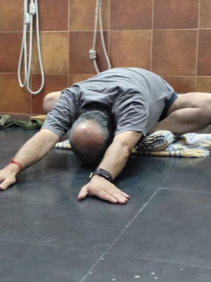 A forward bend in Virasana (Hero Pose).
