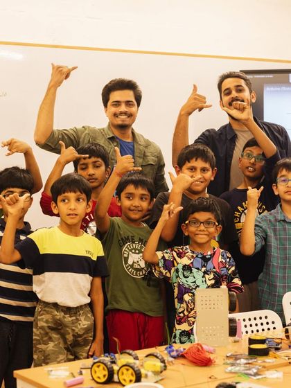 The robotics team and their teachers celebrate a successful showcase. This is the proud moment after weeks of hard work, tinkering, and learning together.