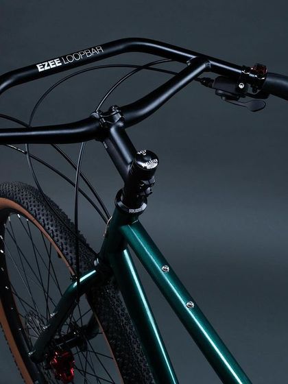 The cockpit of the 'KETTLEXPRESS' features an EZEELoopbar handlebar. This unique handlebar design offers multiple hand positions, which is crucial for reducing fatigue on multi-day cycling trips.