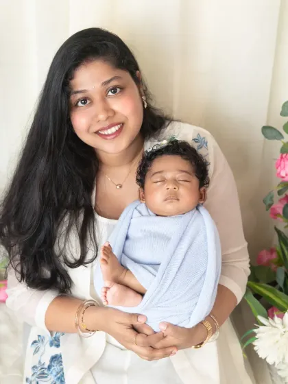 A close-up portrait of a mother holding her sleeping newborn, showcasing the baby's peaceful expression and tiny features.