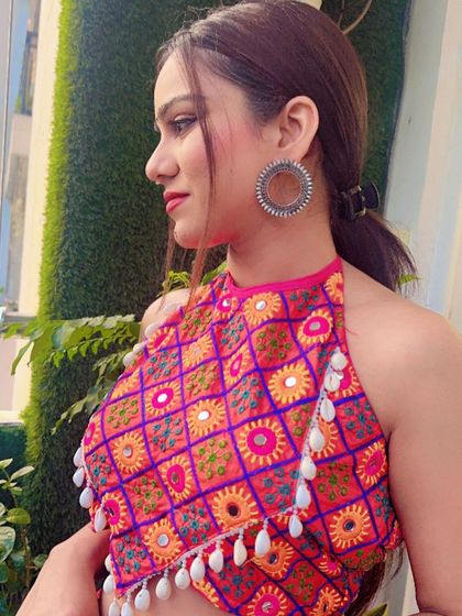 A side view of the embroidered halter-neck blouse, paired with large oxidized hoop earrings.