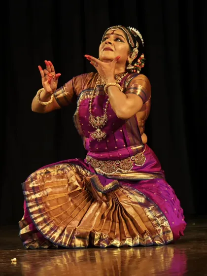 A moment of devotion and surrender during a performance. The upward gaze and open hands signify an offering to the divine, a central theme in many classical Indian dance compositions.