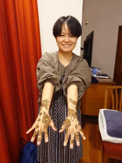 My client from Japan proudly showing both her hands, adorned with a delicate, flowing design that included her special request for a baby elephant.