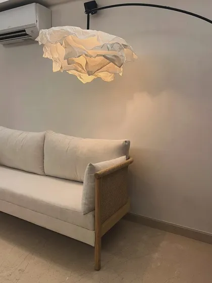 A custom sofa in oak wood with original bamboo cane detailing on the arms, shown in a client's home.