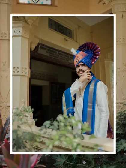 A strong, framed portrait of the groom in his traditional pheta. His confident pose and the classic architectural setting create a regal and timeless image.