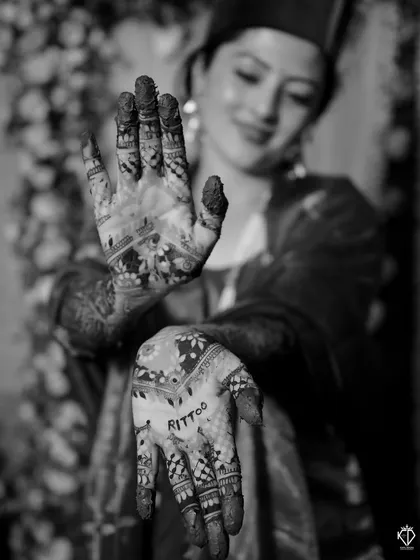 A creative shot focusing on the groom's name written in henna on the bride's hand.