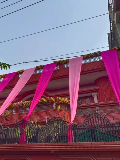 A close-up of balcony decorations with pink drapes and floral garlands. I pay attention to every detail to make your home look perfect for the wedding.