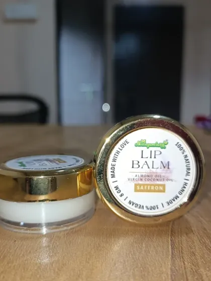 A close-up of our Saffron Lip Balm. It's made with almond oil, virgin coconut oil, and saffron. It is 100% vegan, natural, and handmade with love to care for your lips.
