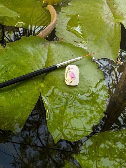 Another example of my team's creativity with hand-painted floral art on a sample nail.