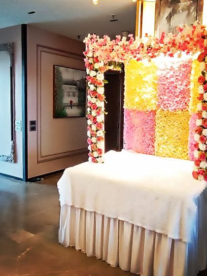 The complete Ganpati mandap setup in a spacious living room. The bright colors and floral design bring a traditional and celebratory feel to the home.