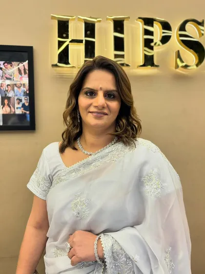 A happy, confident client with her hair styled in soft curls, a timeless look for any occasion.