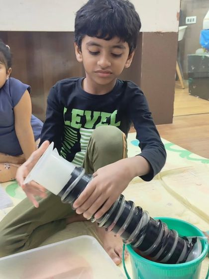 This young scientist is experimenting with an Archimedes screw, a simple machine used for transferring water. It's a great way to visualize engineering principles. (Same as 17)