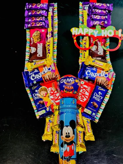 A fun and playful Holi garland for kids, made with their favorite chocolates and a Mickey Mouse themed pencil box.